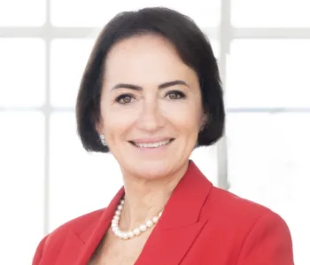 Un primo piano di Maria Luisa Gota, la nuova presidente di Assogestioni. Indossa un completo rosso con collana di perle
