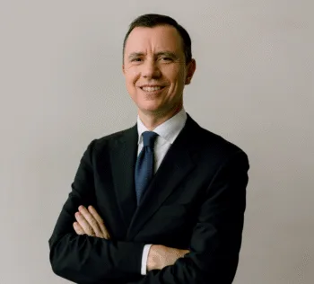 Il responsabile per l'Italia di Ubs AM, Francesco Branda, in una foto professionale. A braccia incrociate e sorridente, indossa una giacca nera con cravatta e camicia bianca