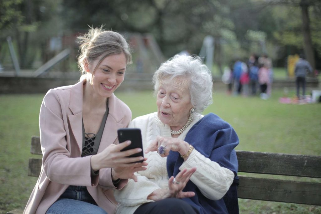 Donna mostra smartphone ad anziana