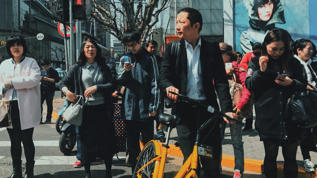 Abitanti di Pechino, in Cina, camminano per la strada
