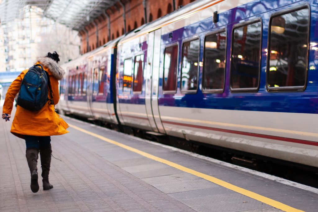 Un treno in partenza con un passeggero che corre per non perderlo