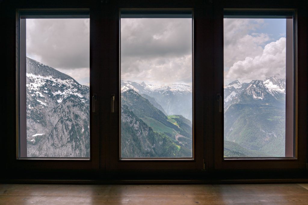 Una finestra chiusa con panorama di montagne innevate all'esterno