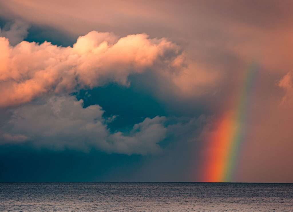 Arcobaleno sul mare con nuvole