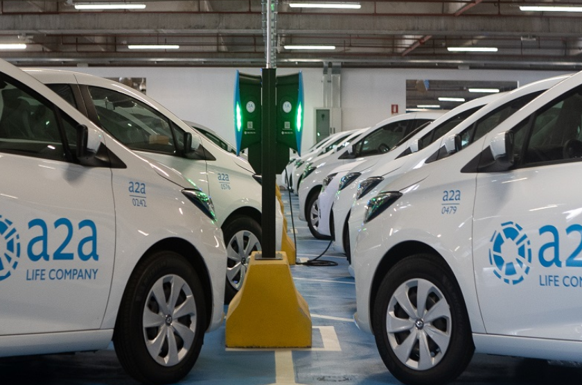 Delle automobili bianche con il logo di A2A sulle portiere sono parcheggiate a spina di pesce in un parcheggio della utility