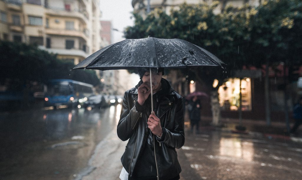 Un uomo con un ombrello in un giorno di pioggia