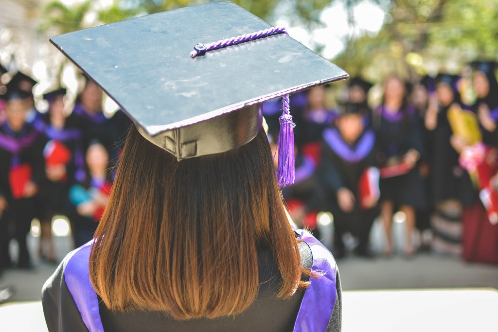 Una studentessa, di spalle, con il tocco della laurea in testa