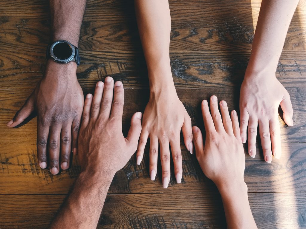 Mani di persone con diverso colore della pelle