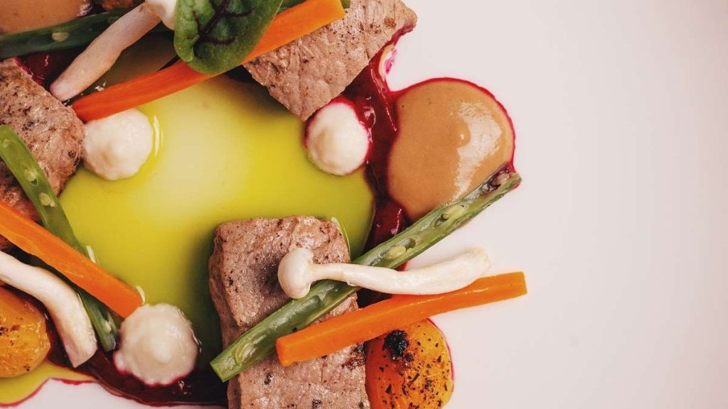 Un cuoco griglia della carne coltivata