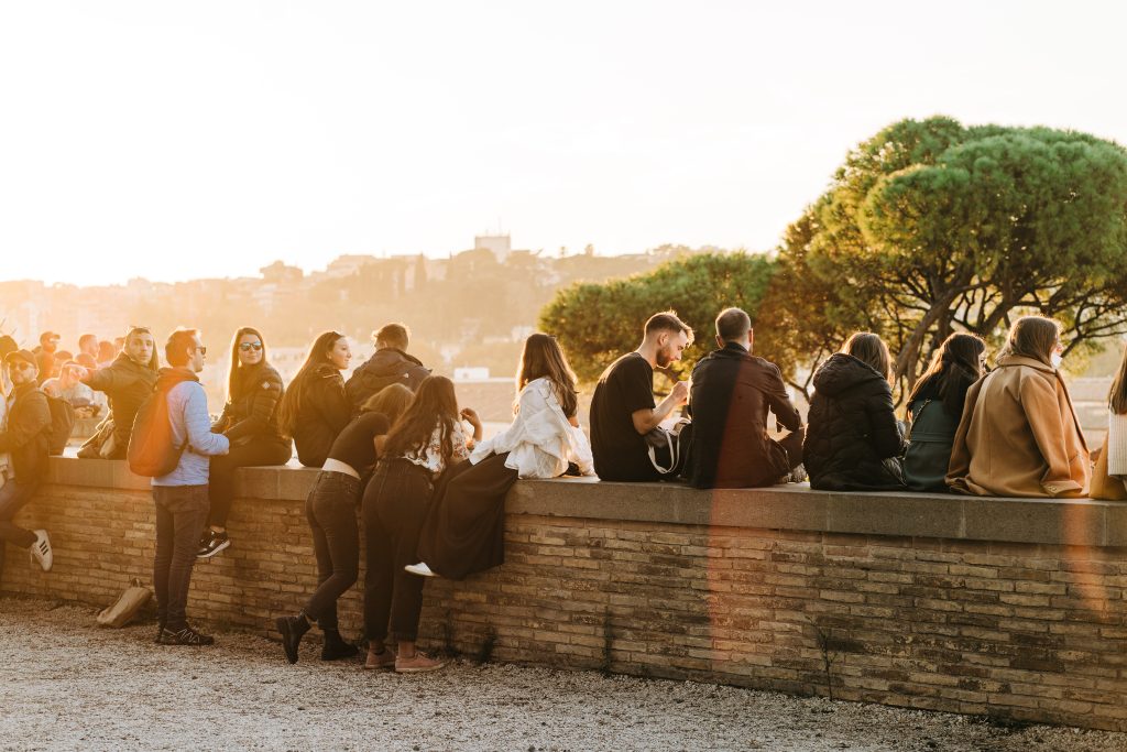 Un gruppo di giovani si gode il tramonto panoramico di una città italiana.