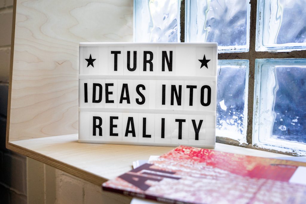 Un piccolo cartello su una scrivania recita: "Turn ideas into reality"