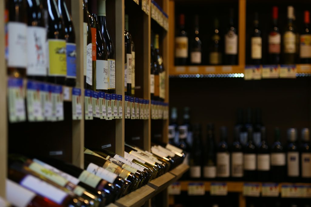 Numerose bottiglie di vino allineate in una cantina