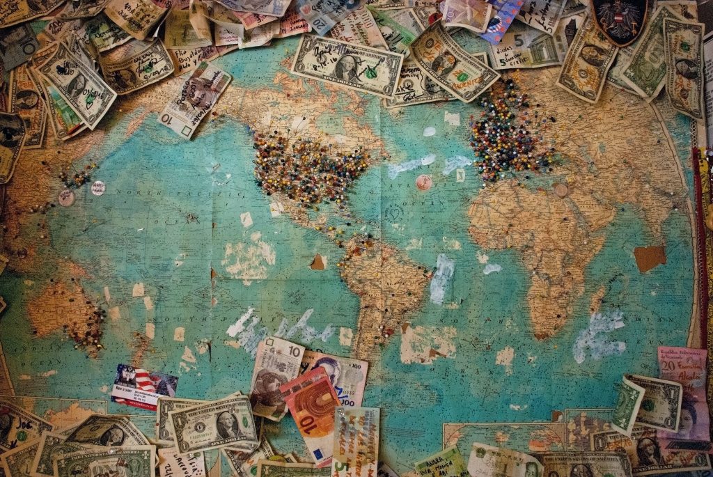 Una mappa del mondo con alcuni mazzi di banconote poggiati