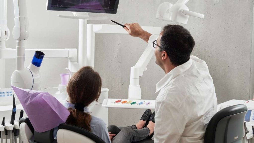 Un medico illustra un esame a una pazienze vittima di infortunio sul lavoro