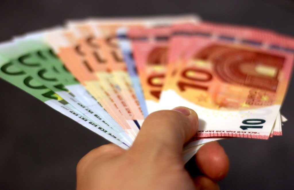 Una mano tiene un ventaglio fatto da euro in banconote