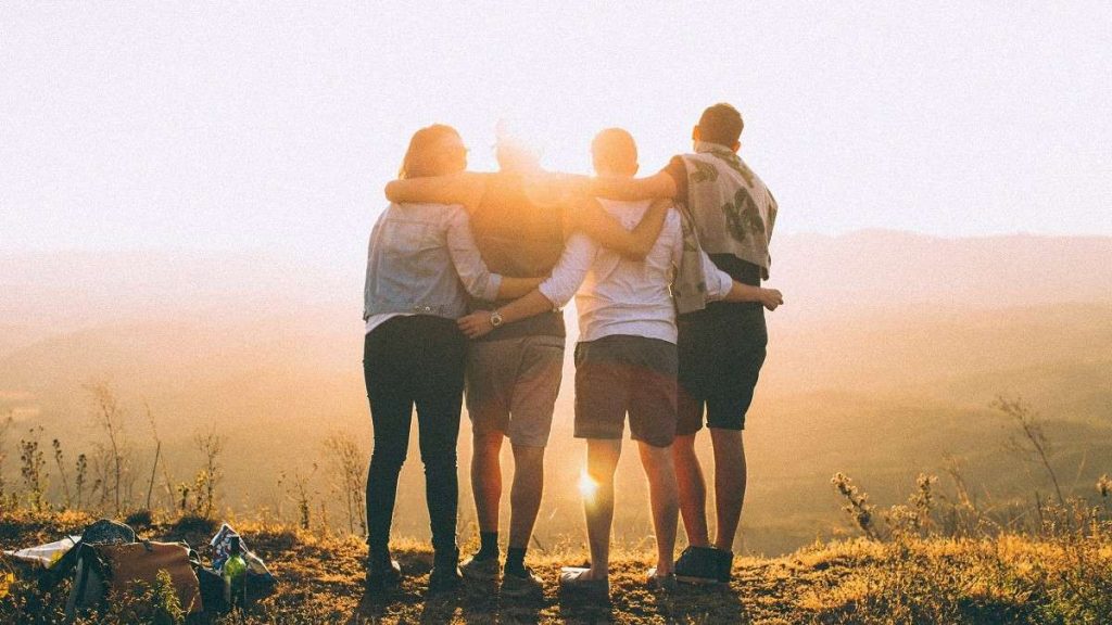 I soci di una comunità energetica si abbracciano al tramonto
