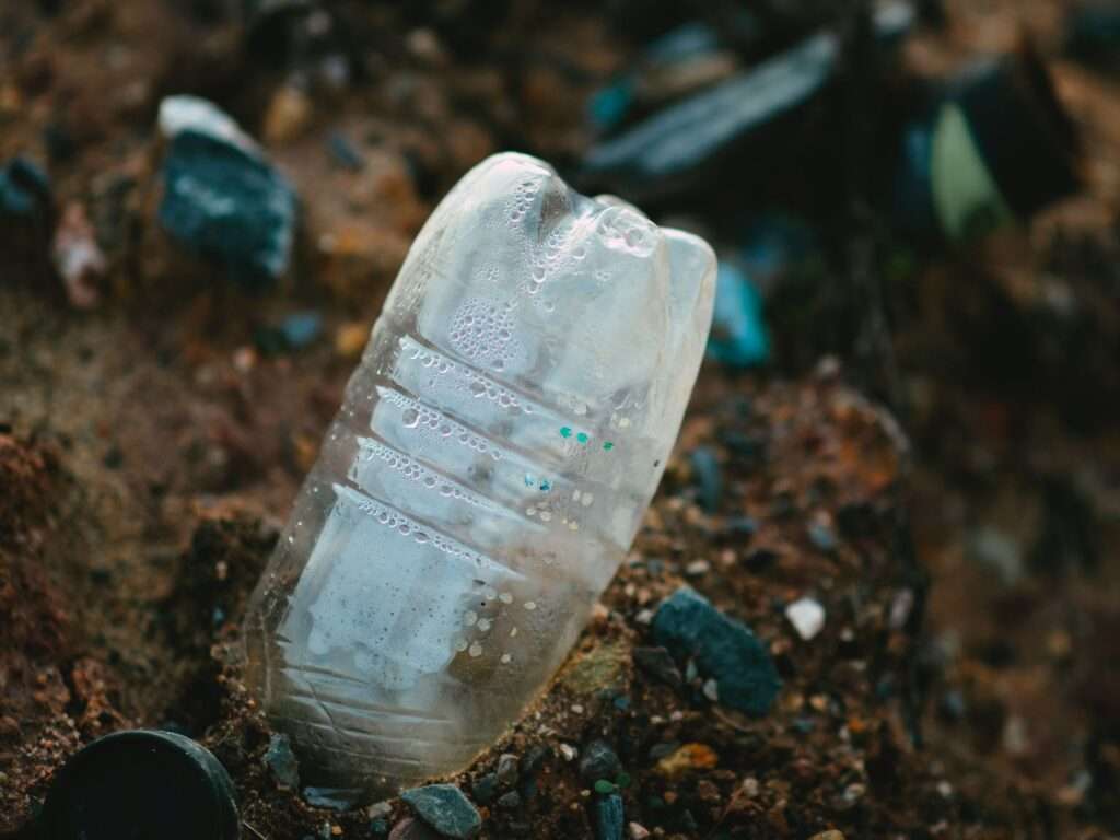 Una bottiglia di plastica vuota abbandonata su una spiaggia rappresenta una esternalità negativa dell'impresa che l'ha prodotta