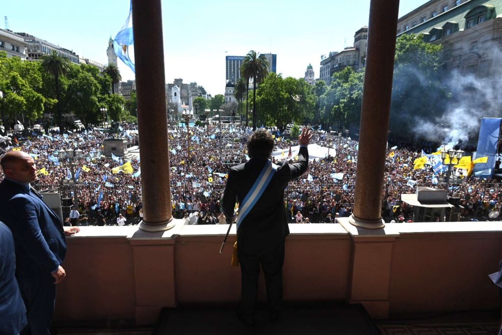 Il nuovo presidente dell'Argentina, Javier Milei, di spalle sul balcone della Casa Rosada saluta la folla riunita in Plaza de Majo