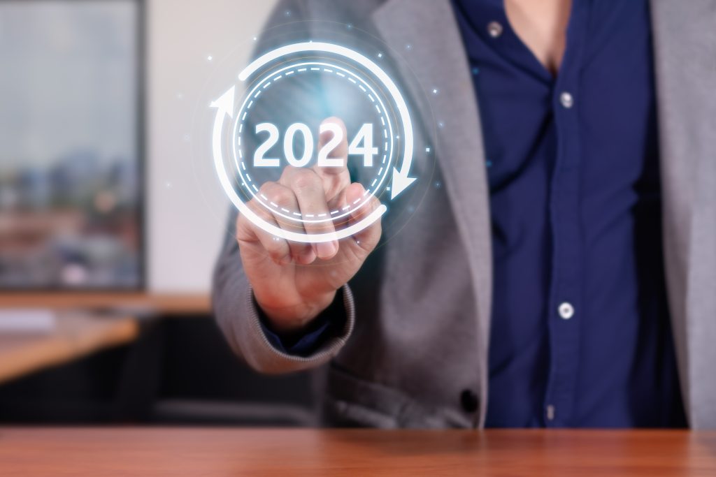 La fotografia mostra una persona in piedi che disegna virtualmente con un dito l'anno 2024.