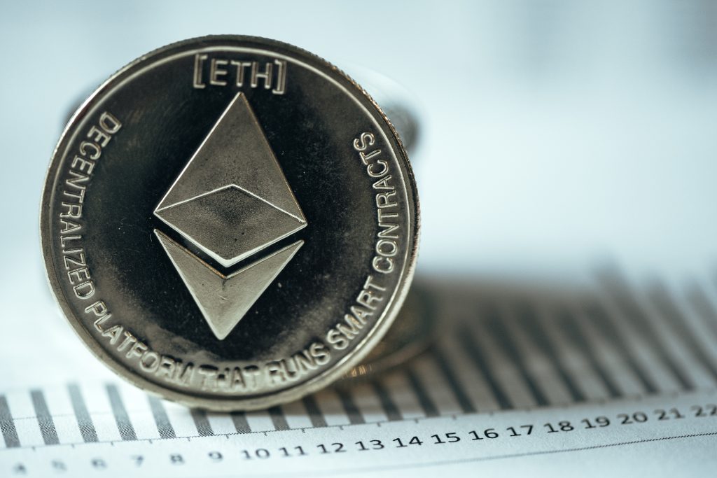 Una criptomoneta di Ethereum, in verticale, sopra un foglio di documenti scritti