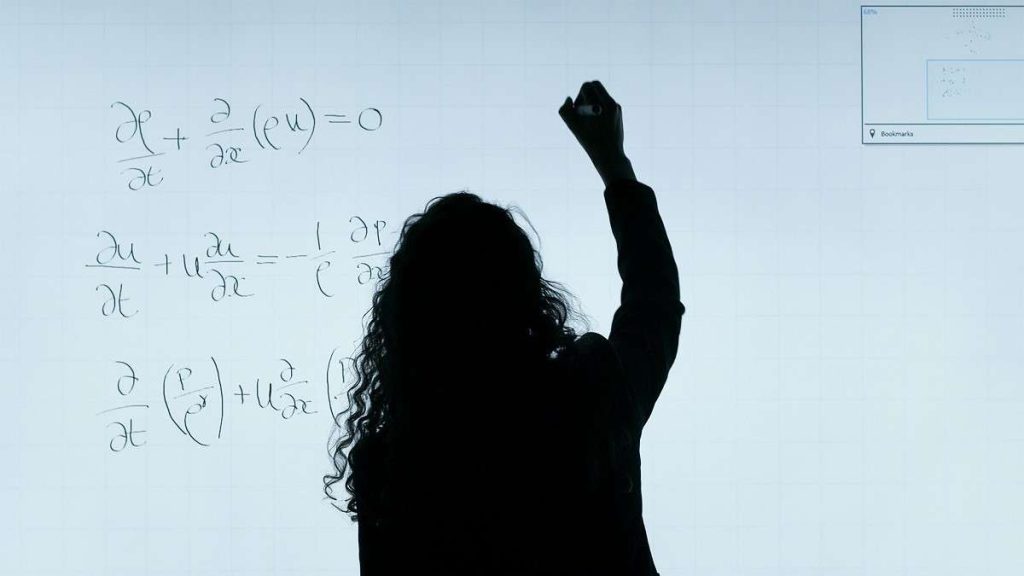 Una giovane professionista scrive formule alla lavagna