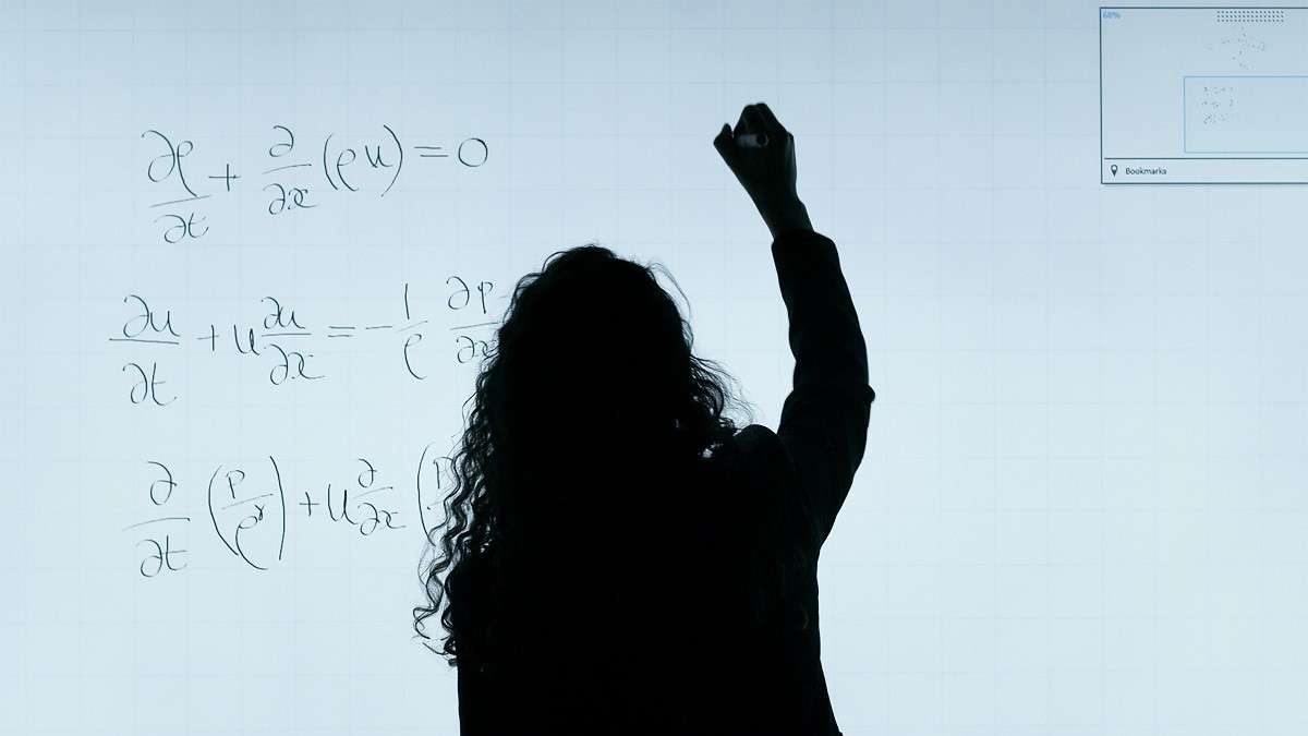 Una giovane professionista scrive formule alla lavagna
