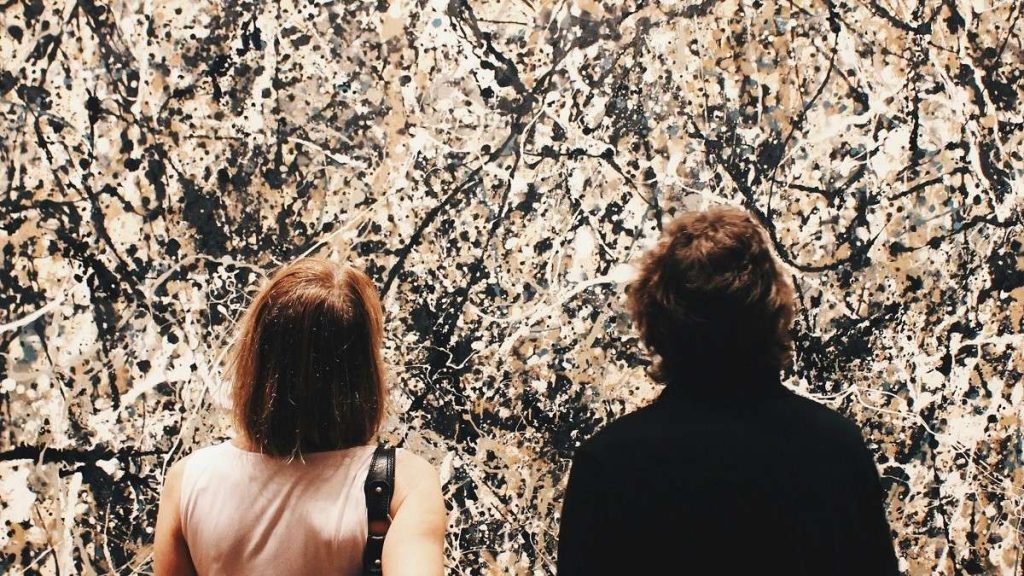 Due visitatori di un museo ammirano un'opera di Jackson Pollock