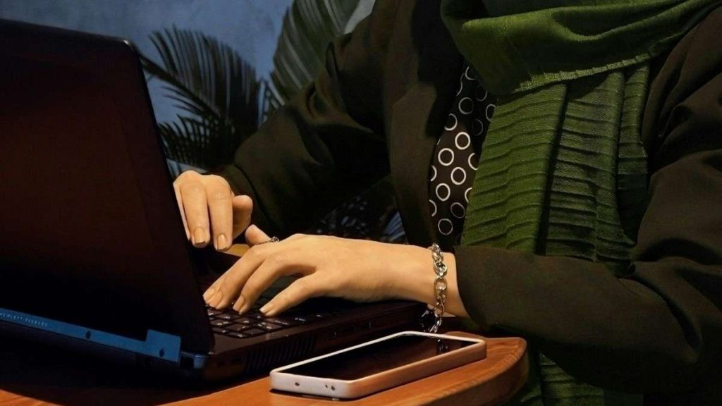 Una lavoratrice scrive al computer la lettera di dimissioni dal lavoro