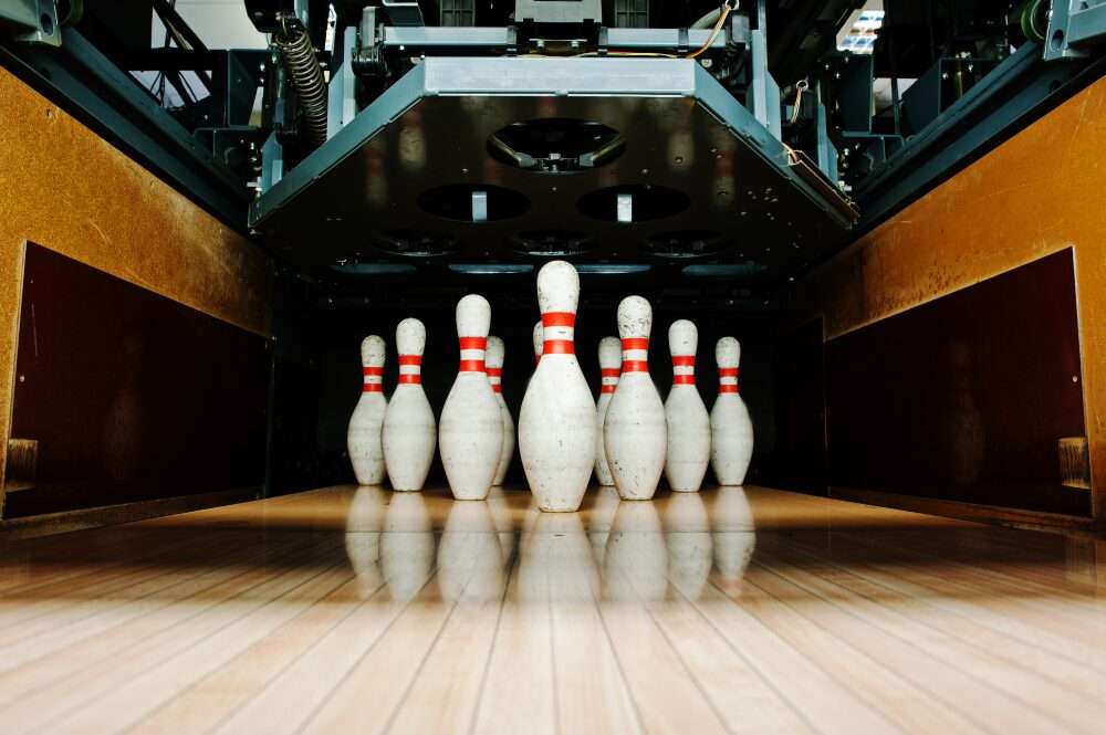 Nell'immagine una pista da bowling con i suoi birilli