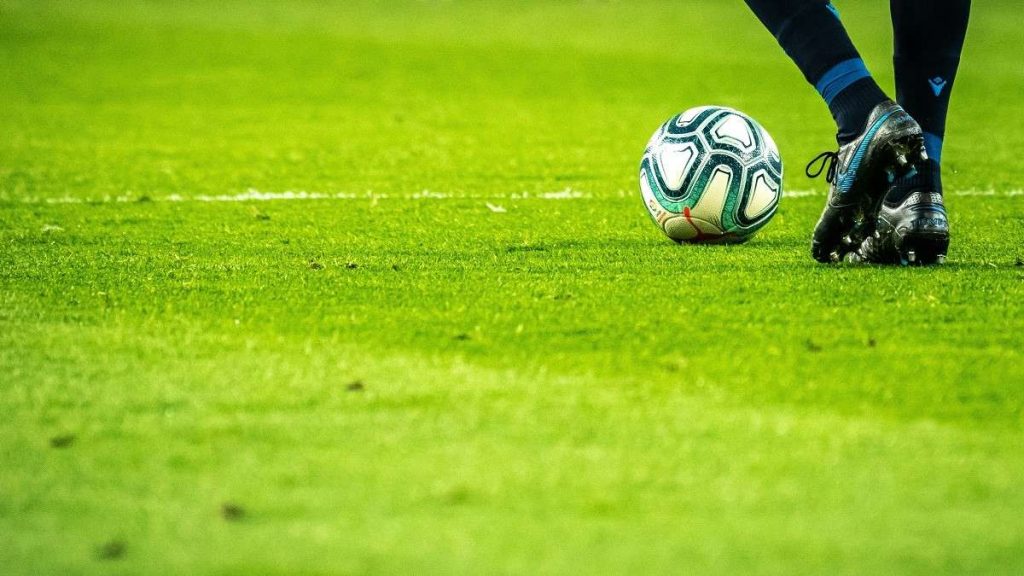 Un calciatore in campo col pallone