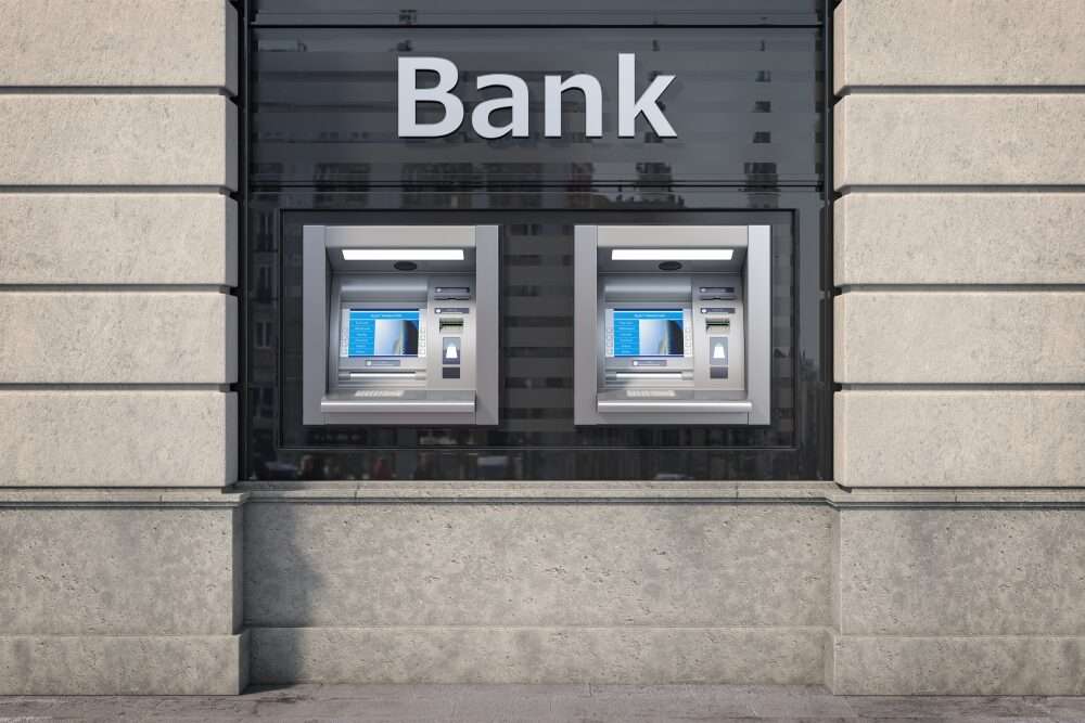 L'immagine mostra due sportelli automatici di un istituto bancario, affiancati e sormontati dalla scritta bank