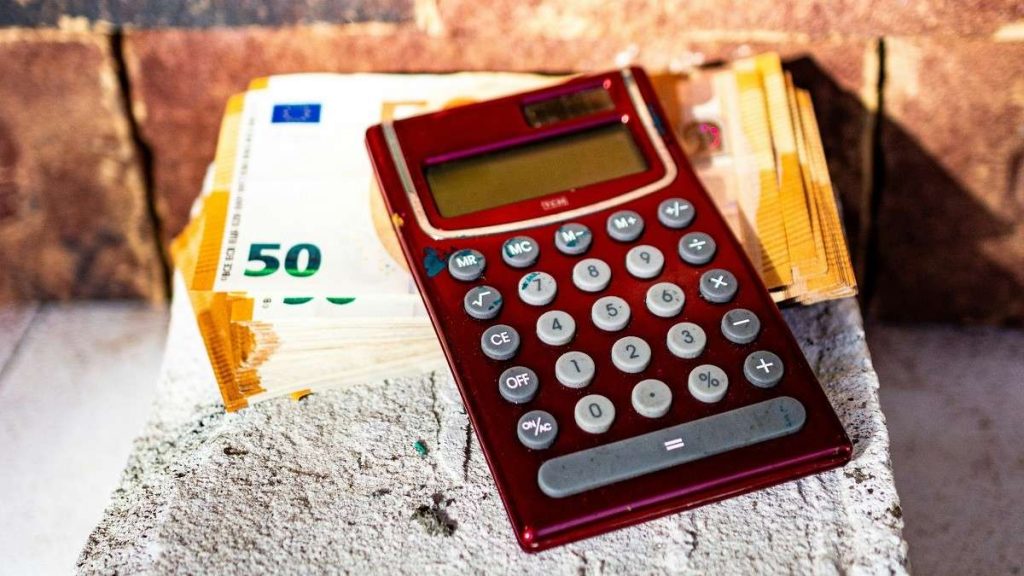 Un risparmiatore con calcolatrice e banconote da 50 euro