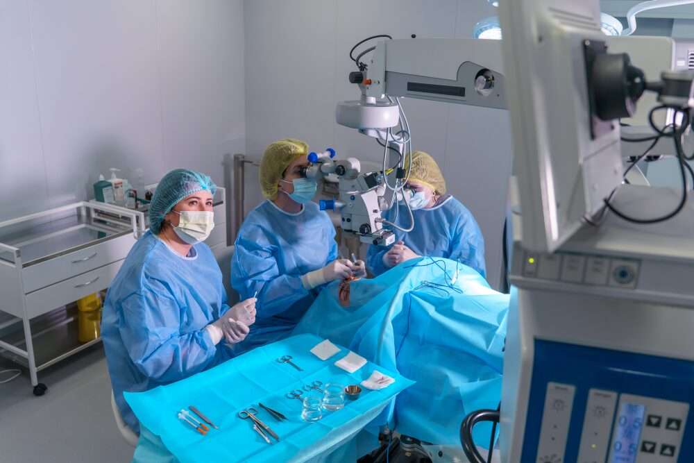 L'immagine mostra una sala operatoria dove è presente un robot che opera insieme agli altri medici