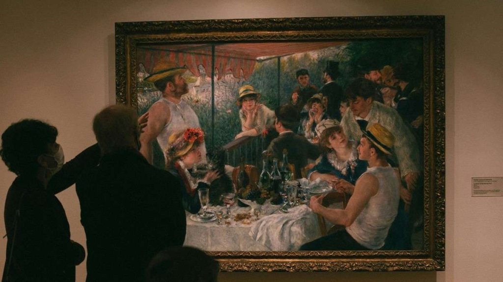 Visitatori ammirano un quadro di Pierre-Auguste Renoir in un museo