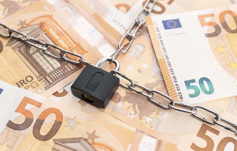 Nell'immagine vengono mostrate delle banconote in euro bloccate da un lucchetto