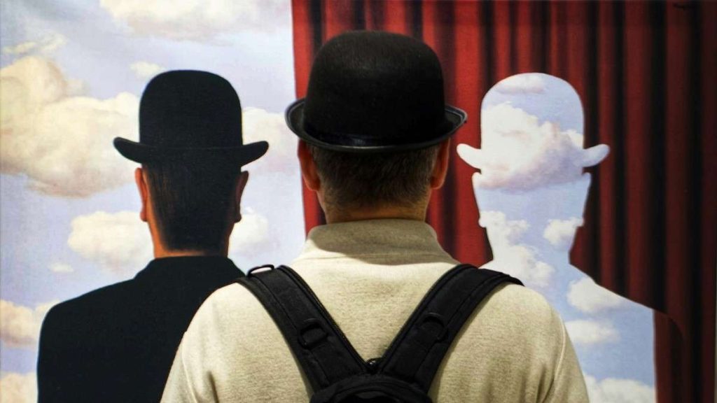 Una persona simula un quadro di Magritte