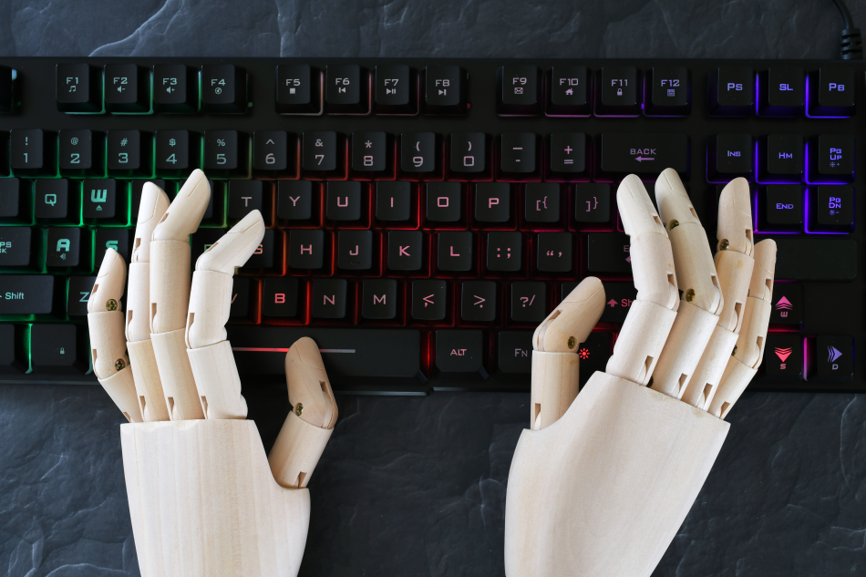 Le mani di un androide scrivono su una tastiera