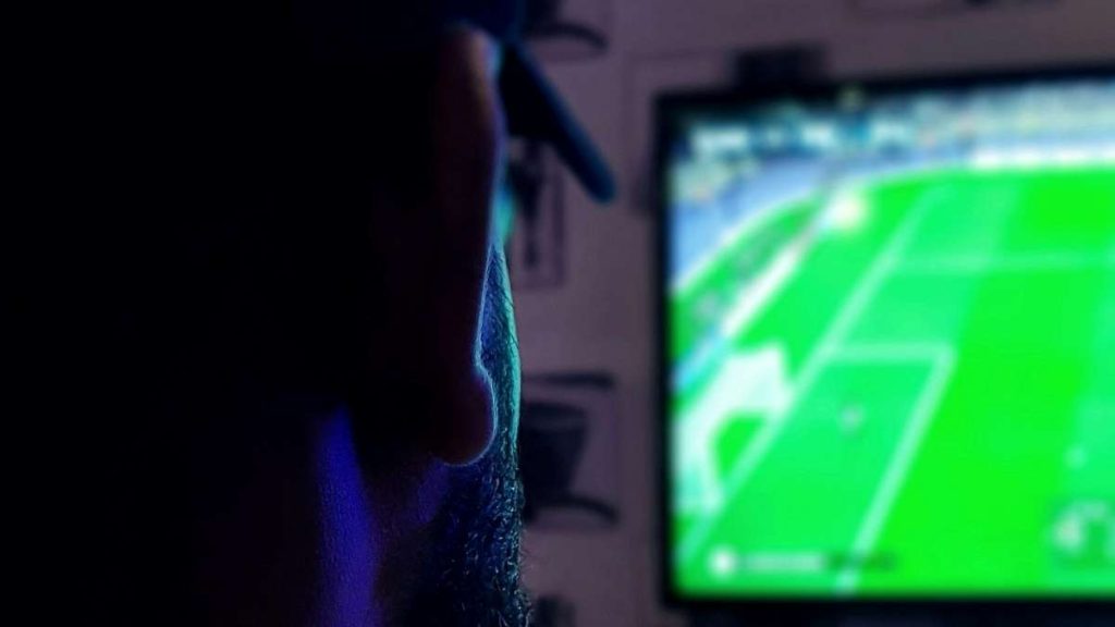 Una persona guarda una partita di calcio in tv