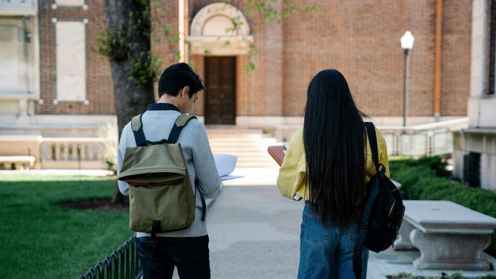 Uno studente e una studentesse camminano nel campus di un'università