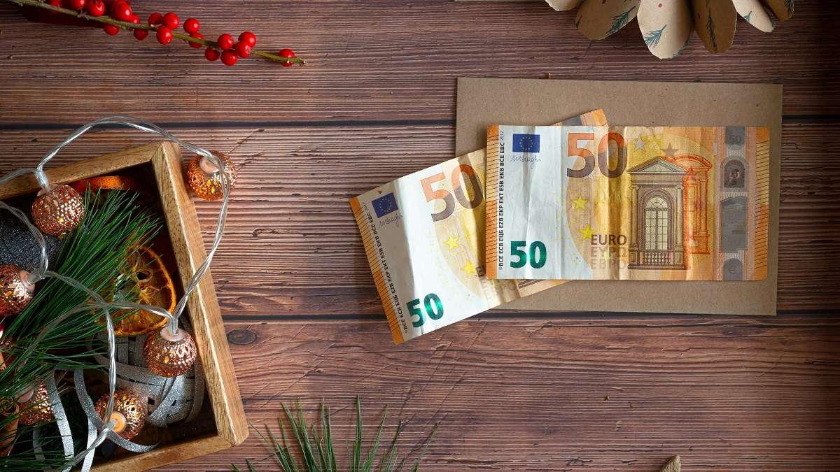 100 euro su un tavolo di legno come dono di Natale