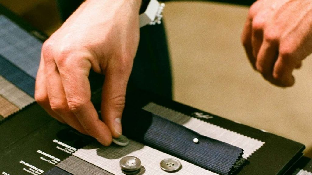 Un sarto lavora su un pezzo di stoffa
