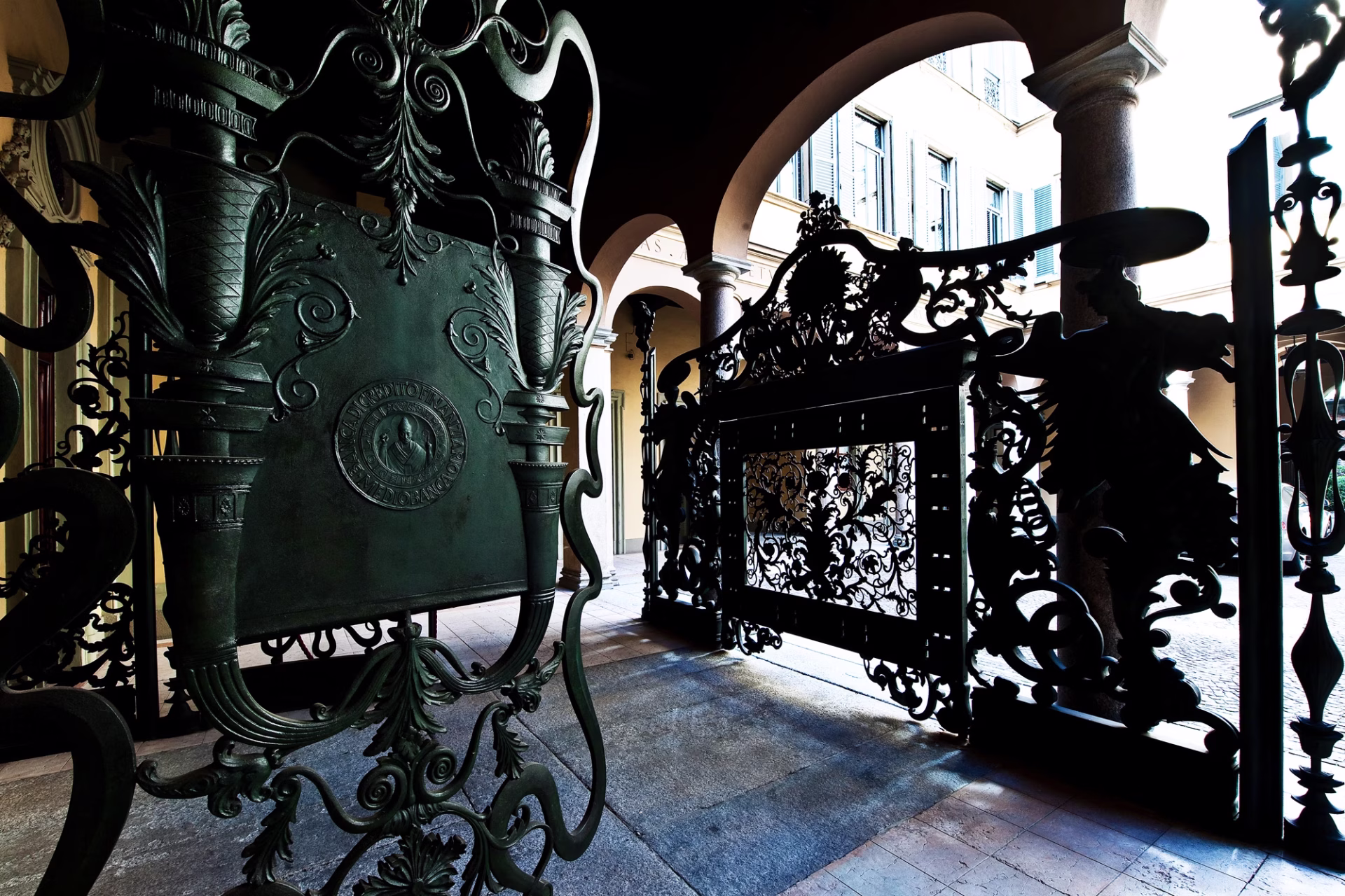 L'ingresso della sede di Mediobanca a Milano. Il cancello, chiuso, visto dall'interno, lascia intravvedere la piazzetta Cuccia all'esterno