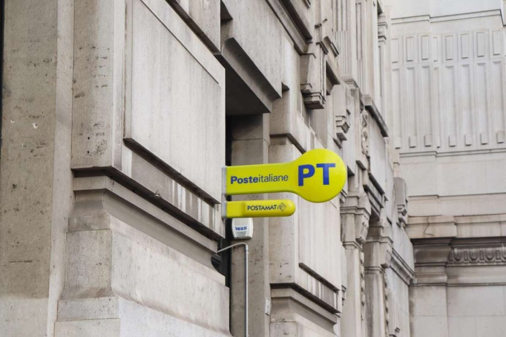 Insegna Poste Italiane PT e Postamat su edificio storico, servizi bancari e postali in Italia, buoni fruttiferi compresi.