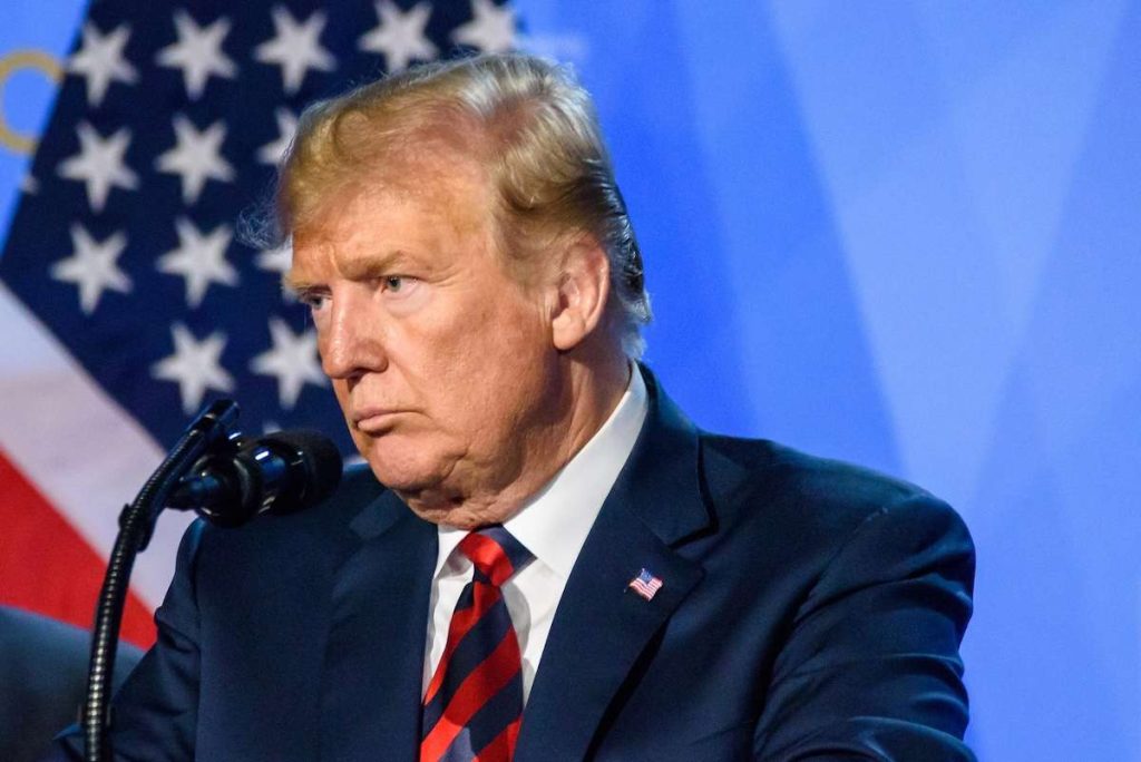Donald Trump in conferenza stampa davanti alla bandiera USA, discorso ufficiale elezioni 2024
