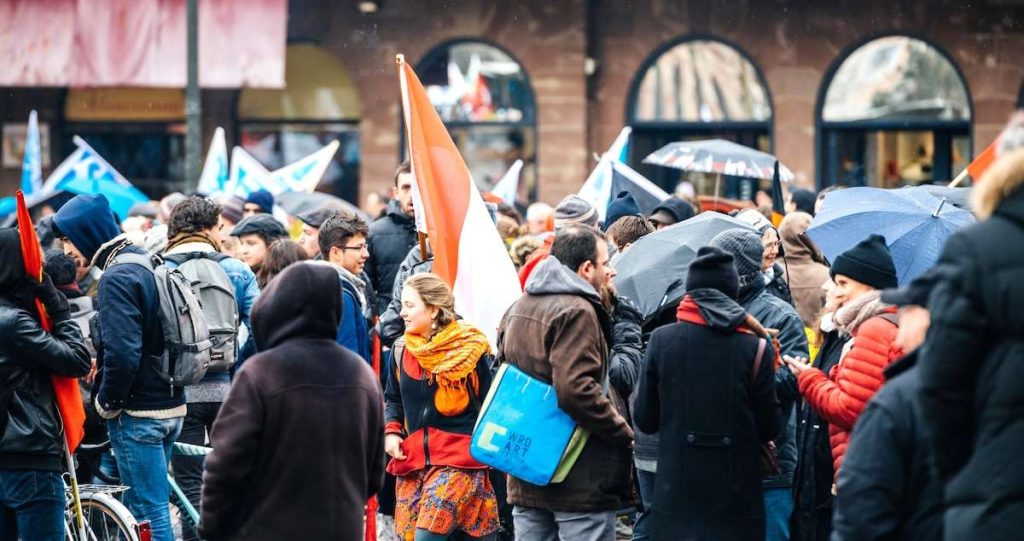 Scioperi a novembre 2024: folla di manifestanti con bandiere.