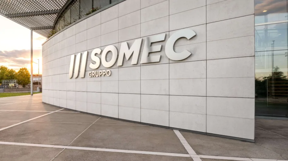 L'ingresso della sede del gruppo Somec. Un muro di pietra bianca accanto alla porta riporta il logo con il nome dell'azienda