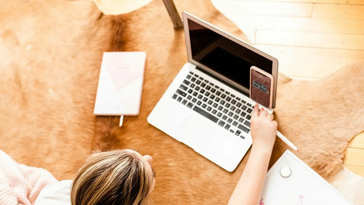 Una donna fa un calcolo al telefono e al computer