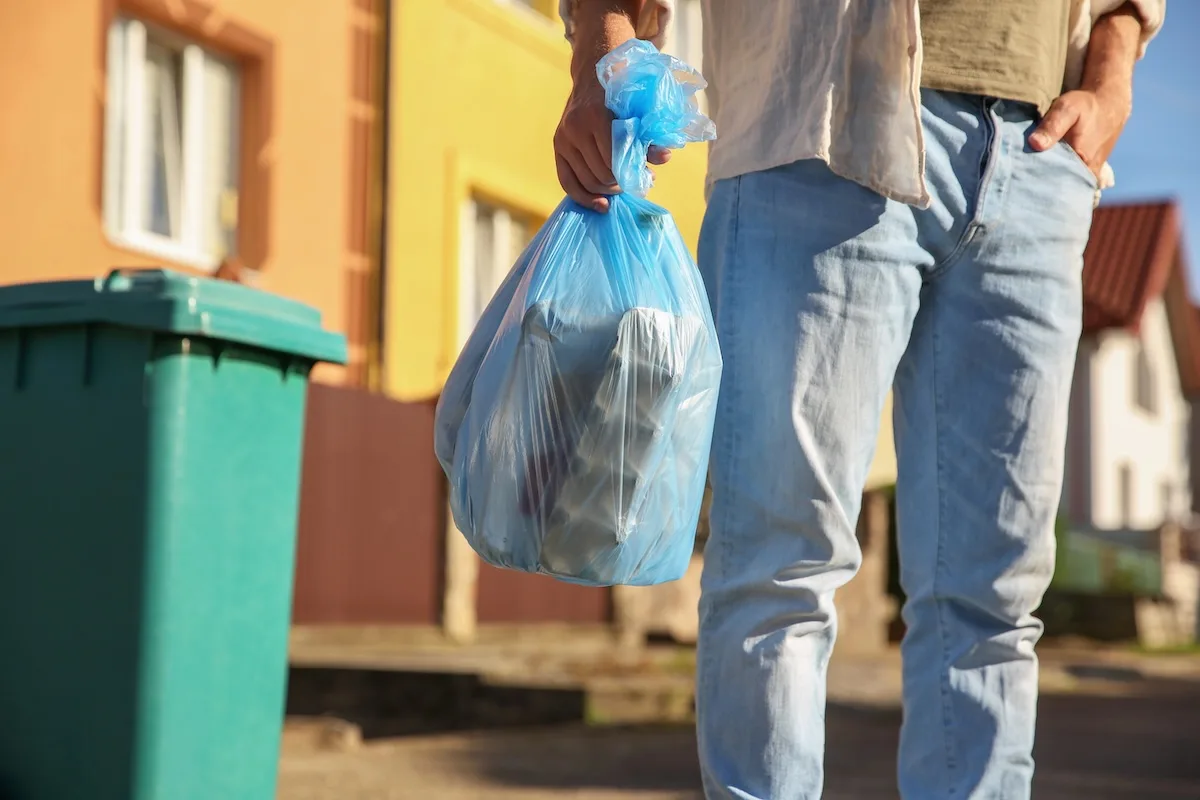 uomo porta fuori rifiuti su cui paga la tari