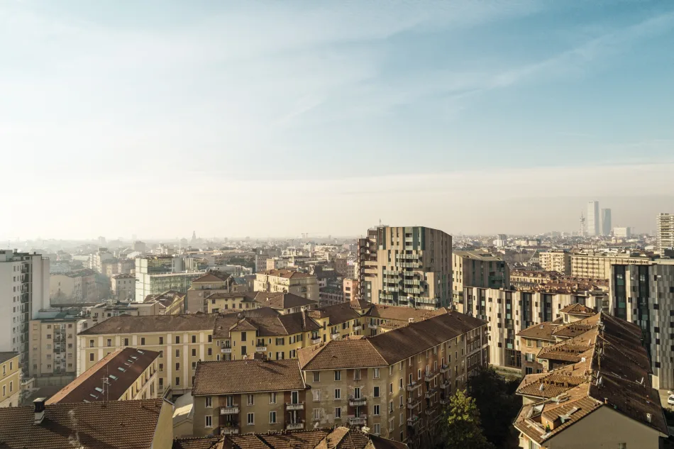 Una vista dall'alto della città di Milano, in una giornata di sole. Sullo sfondo si vedono i grattacieli delle Tre Torri