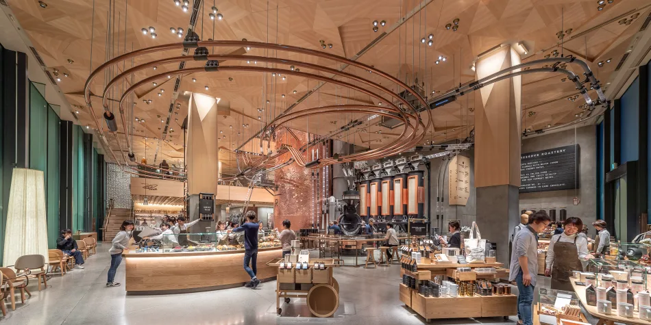 Interno della Starbucks Reserve Roastery di Tokyo, con un design moderno e innovativo, caffè in primo piano e clienti che si godono l'atmosfera.