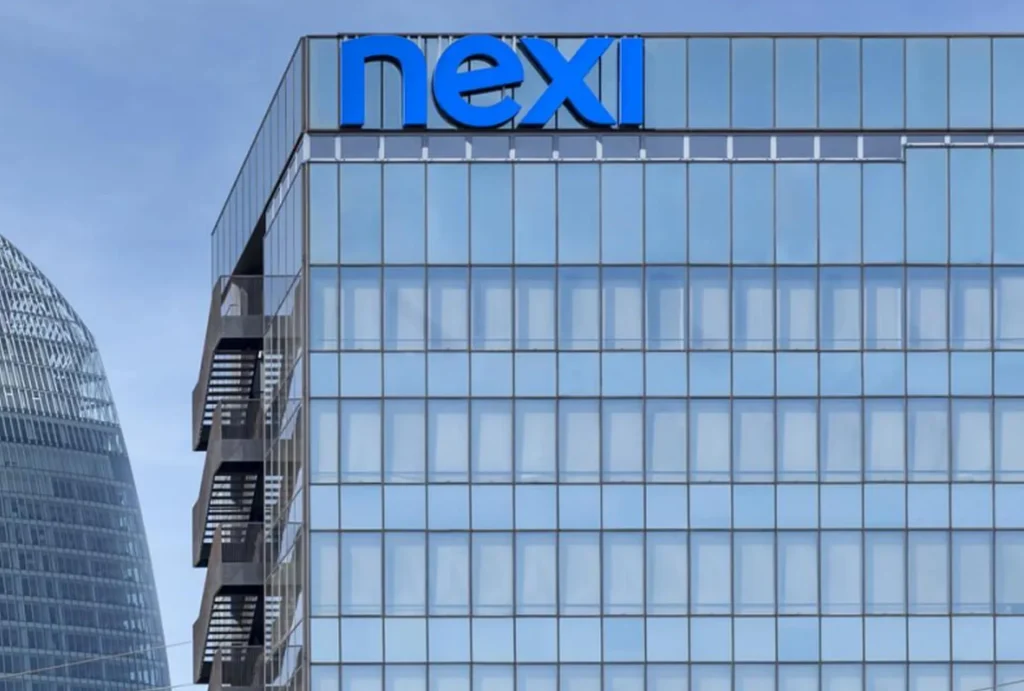 Sede centrale di Nexi, una moderna struttura aziendale con pareti di vetro e il logo Nexi visibile sulla facciata.
